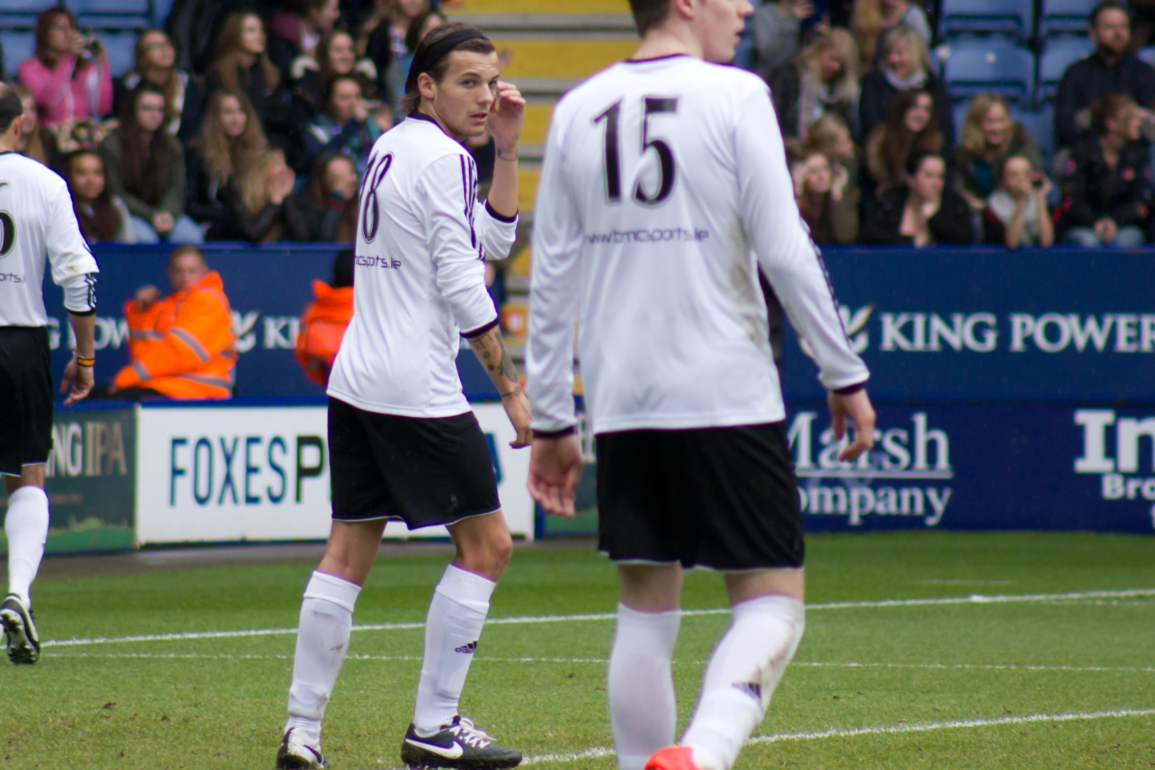 a soccer player stands in front of a referee