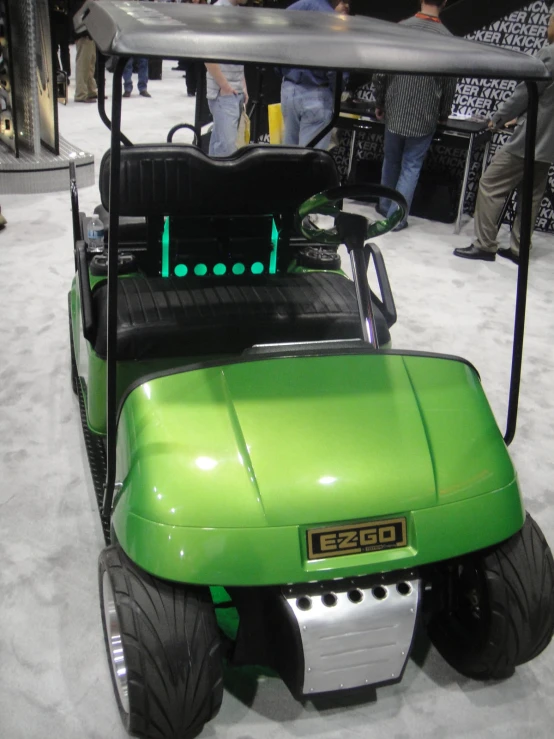 people walking around an exhibit while in a green golf cart