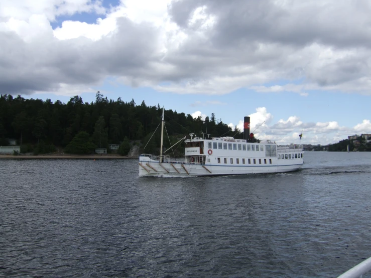 the large white boat is traveling along the water