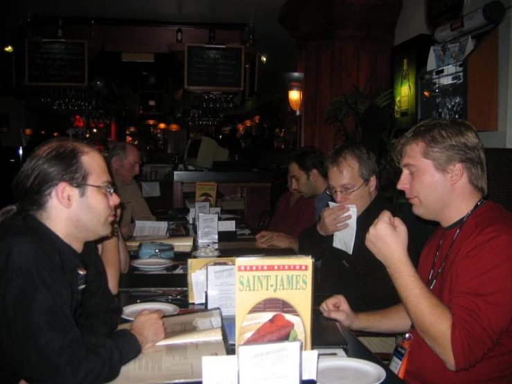 four men sitting at the table having a conversation