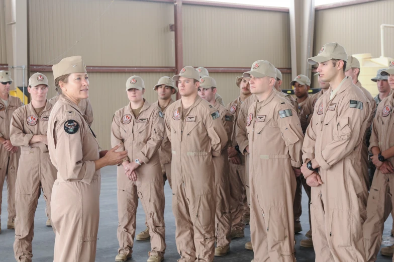 two men talking to a group of military personnel