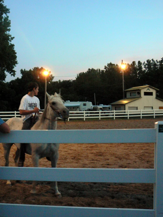 two people are riding horses inside the arena