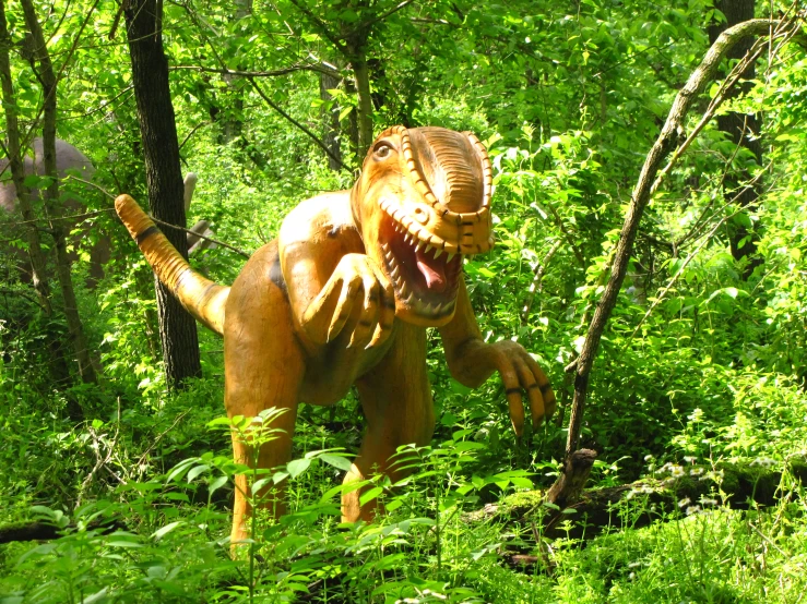 a dinosaur in the middle of some green plants