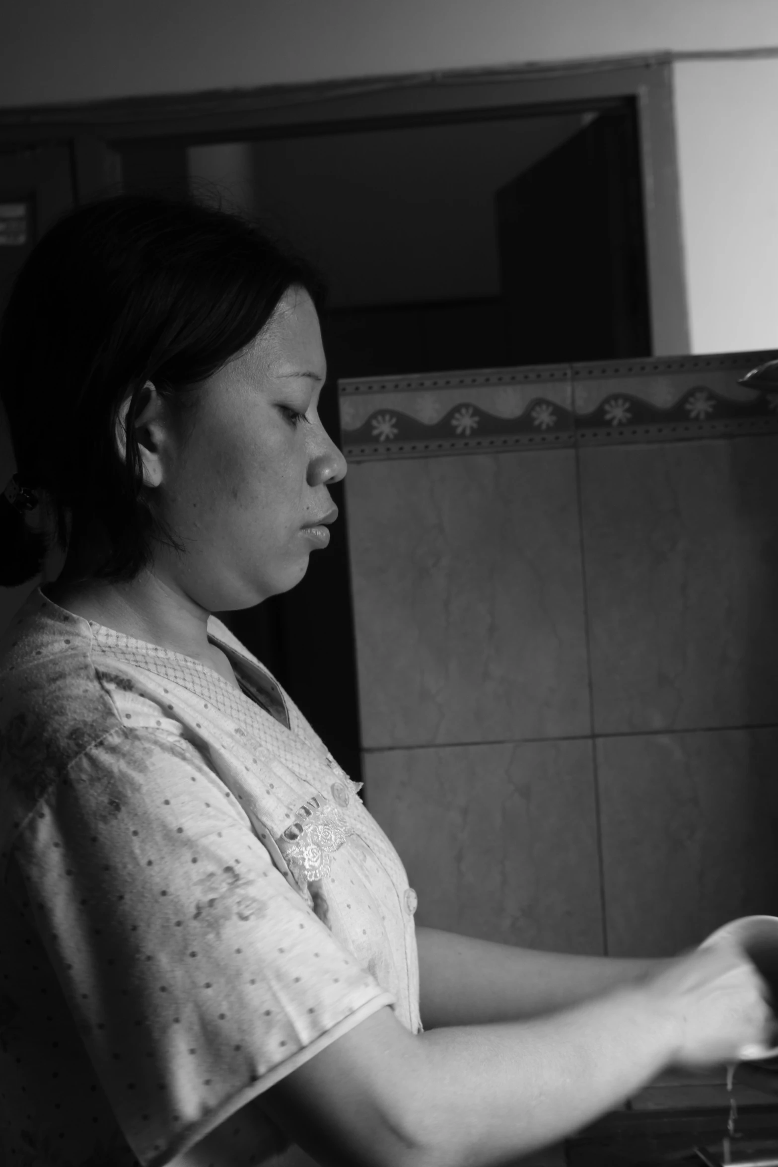 a woman looking over a sink with no faucet