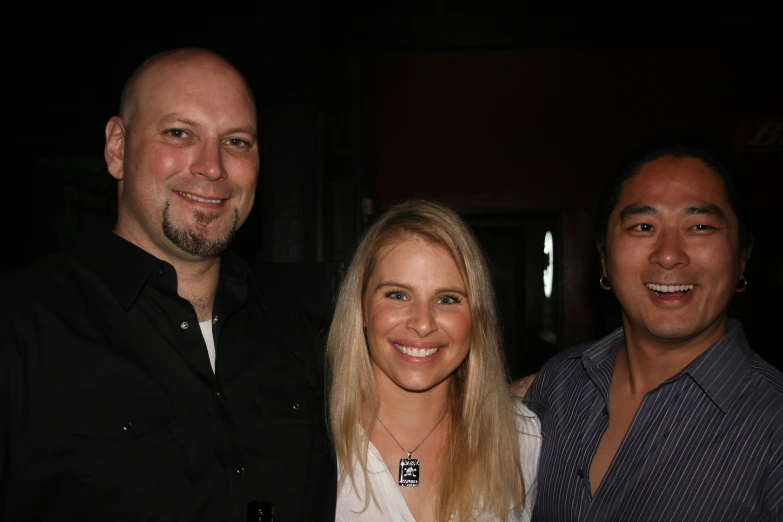 three people are posing for the camera