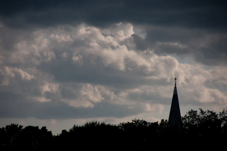 a tower has a steeple on a cloudy day