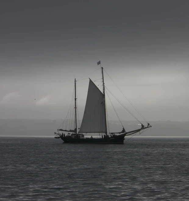 a black and white po of a sail boat on the ocean