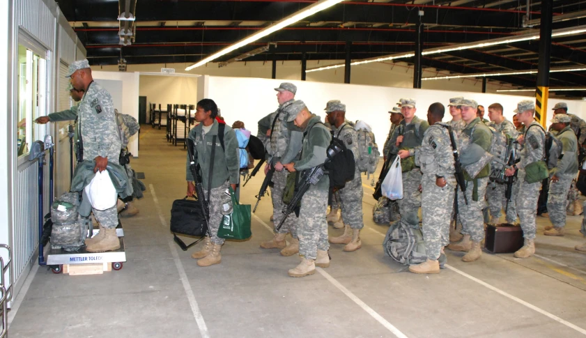 a large group of military men standing in front of luggage