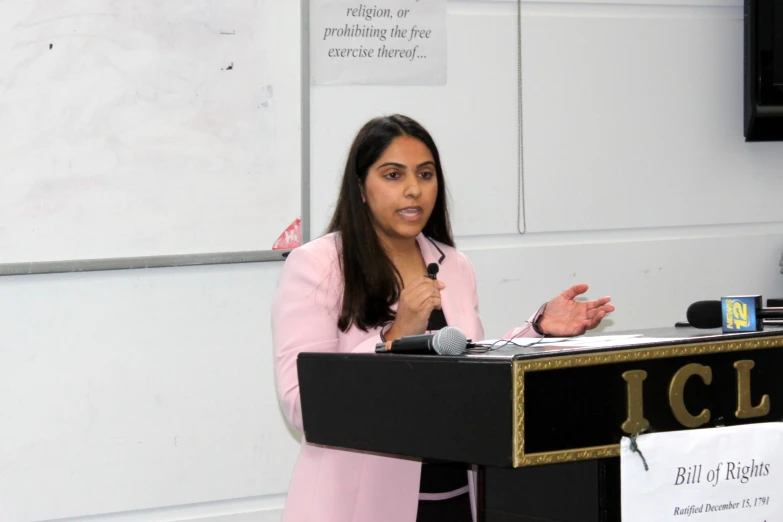 a woman speaking at a podium with a microphone