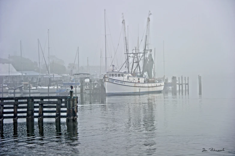 two boats in harbor with fog behind them