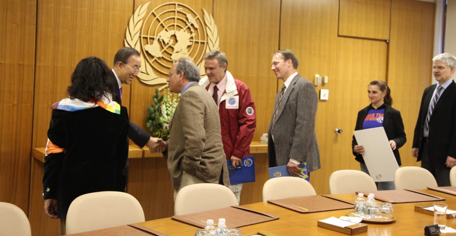 some people standing around a conference table with one man presenting soing