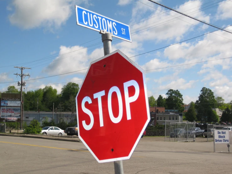 a stop sign with a street and blue street signs