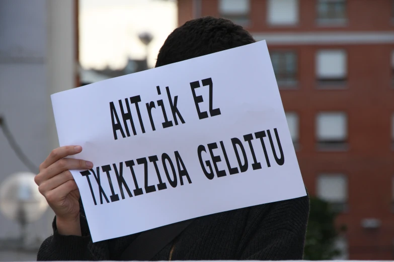 a protester holding up a sign that says antirue e trzzizola geditu