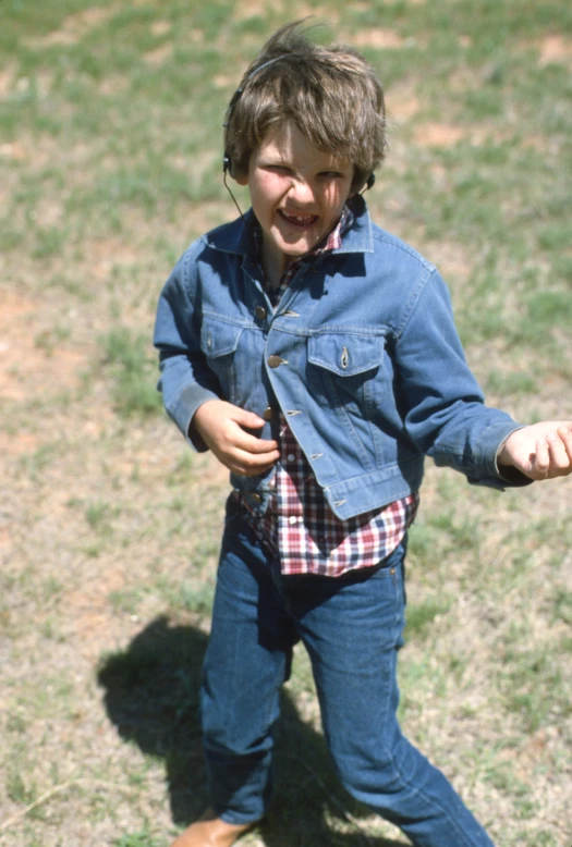 a young child stands in the grass in a park