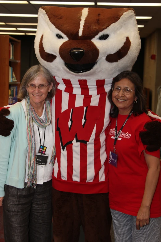 two ladies in front of a big mascot