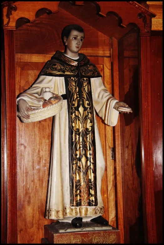 a man statue in a wooden shrine of a priest