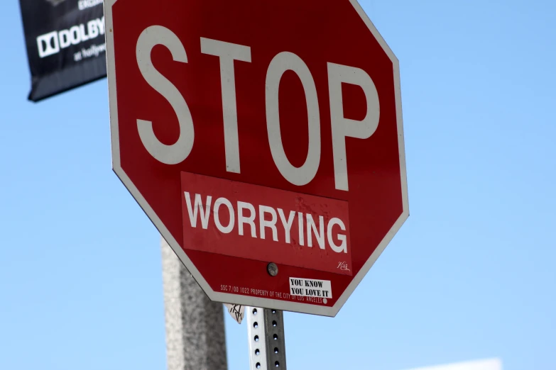 a red stop sign with the word worrying on it