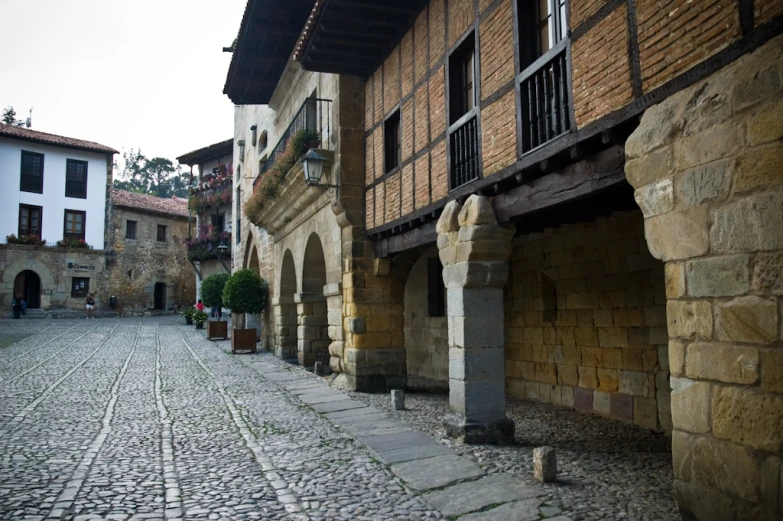 a stone cobble street next to two buildings