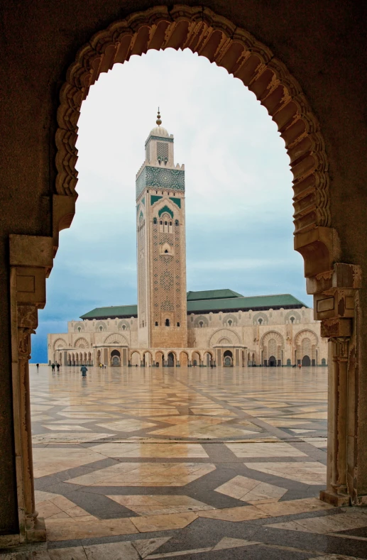 an archway leading to a large building with a clock tower