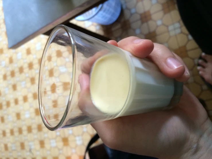a person holding a glass full of liquid