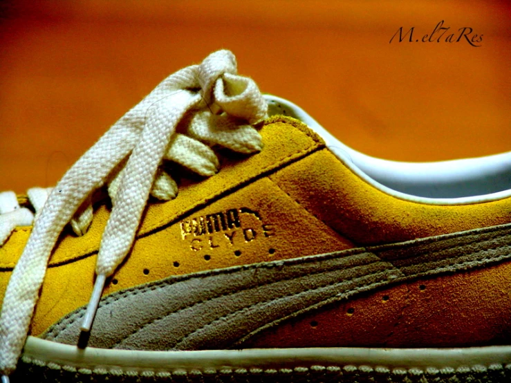 a yellow shoe with white shoestrings is seen