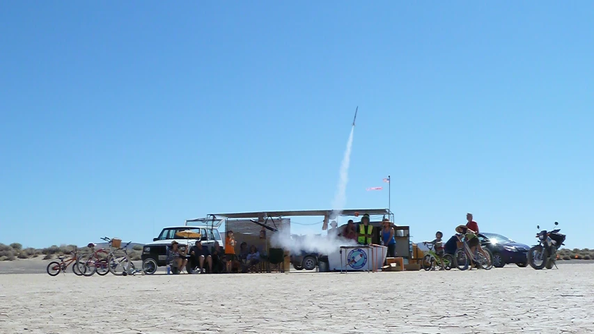 a group of motorcyclists are next to an ice cream truck on the sand