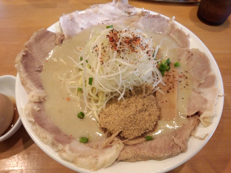 a dinner plate with noodles, meat and some sort of sauce