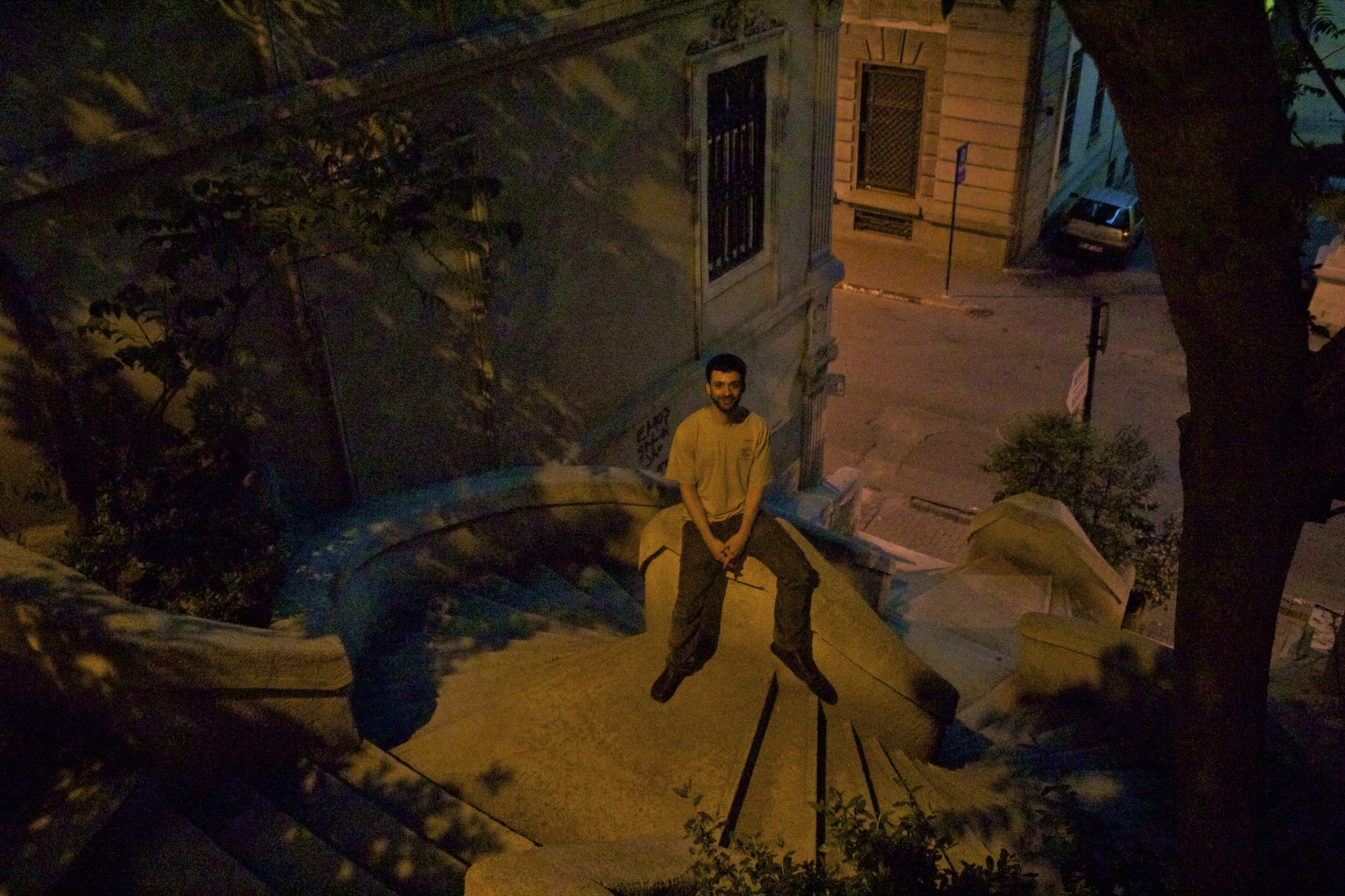 a man sitting on a wooden bench near a street