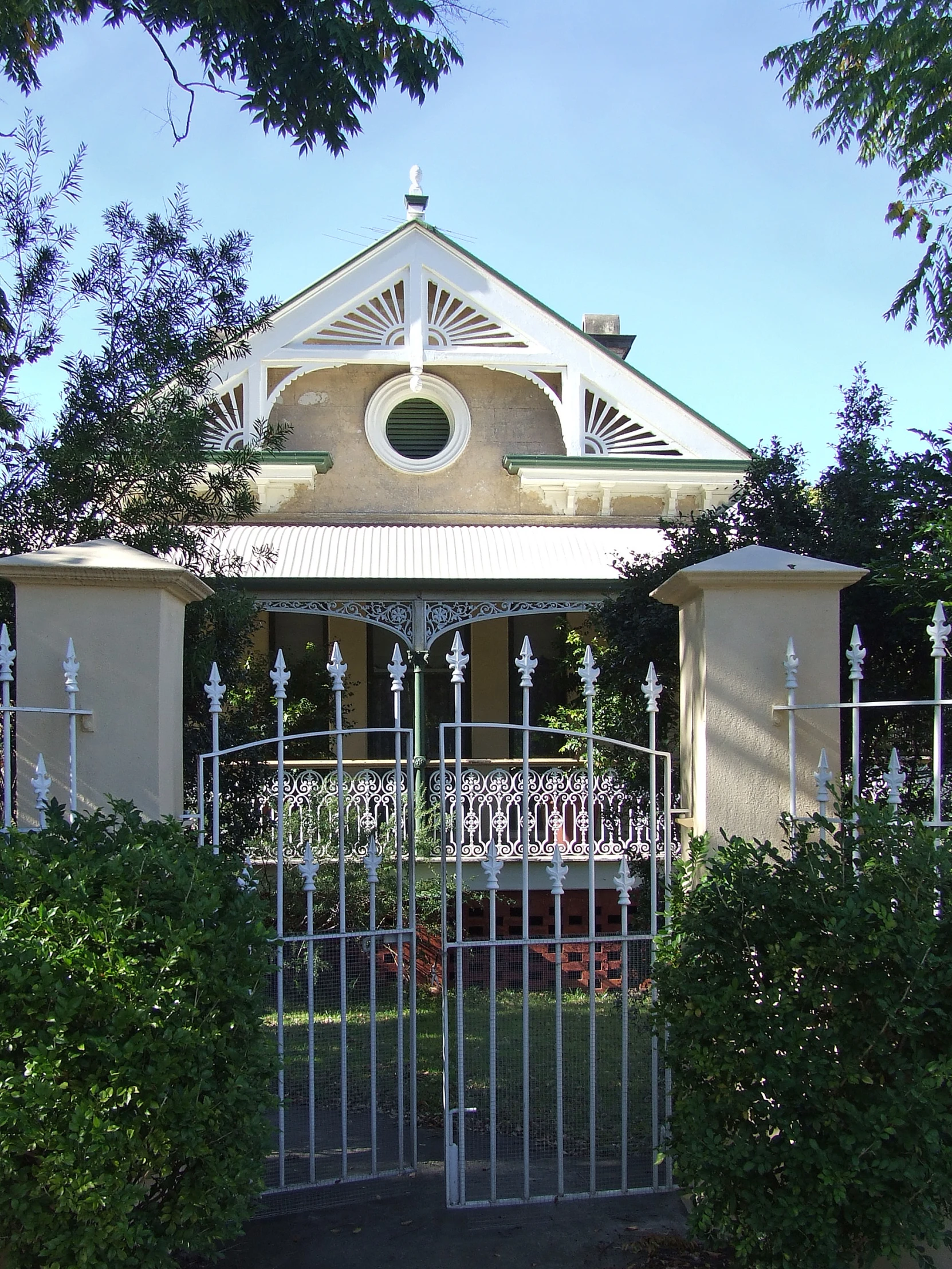 a white gate sits in front of a large house