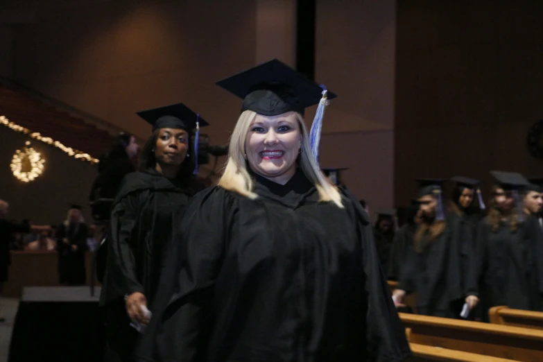 there is a woman in a graduation gown and with her friends