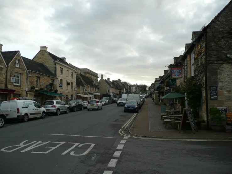 a town is lined with parked cars and buildings