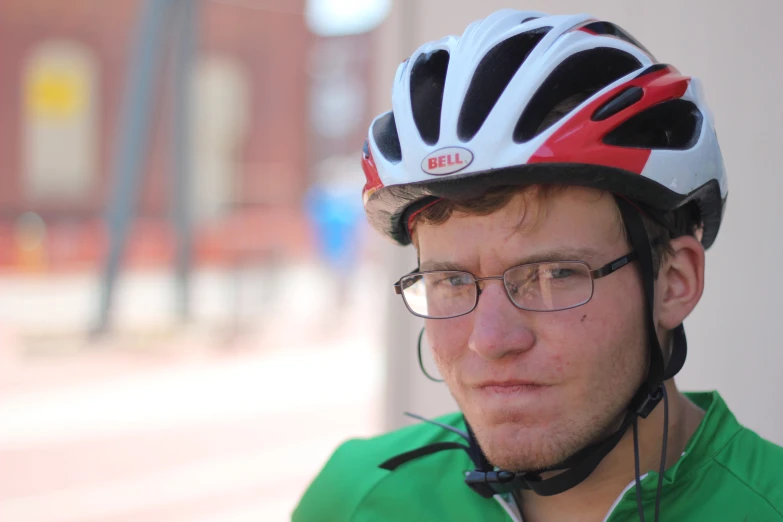 a man wearing a red helmet and glasses looking off into the distance