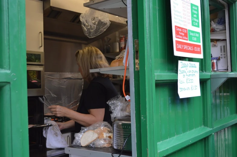 the girl is inside of the restaurant cooking some food