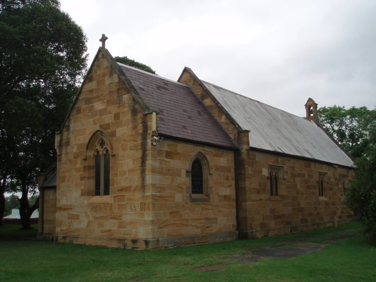 a building with brick siding, large windows and a steeple