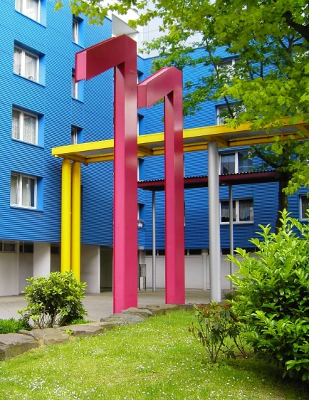 the front entrance to a building with red, yellow, and blue columns