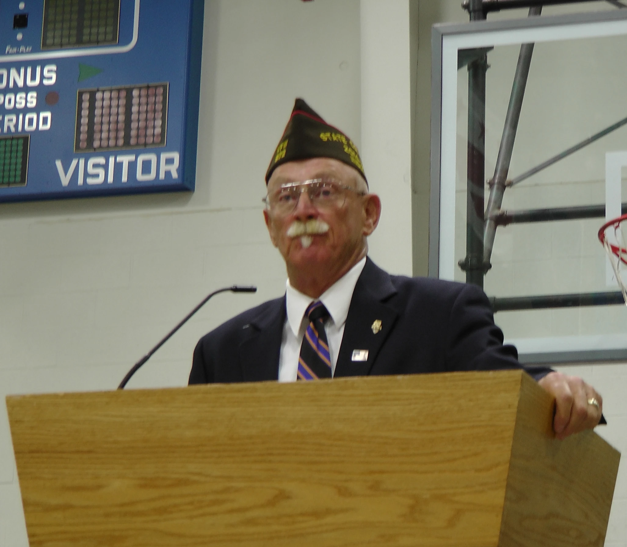 an older man in uniform with a beard talking