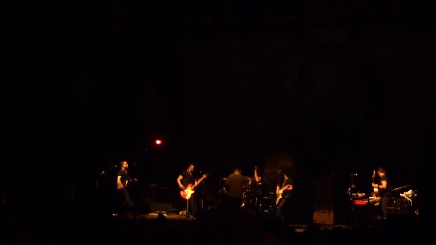 a band performing on a stage in the dark