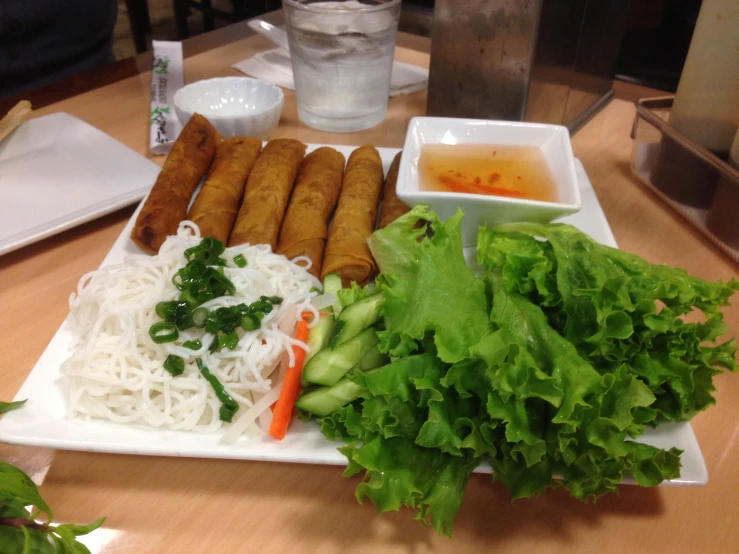 plates and bowls containing lettuce, carrots and chinese rice soup