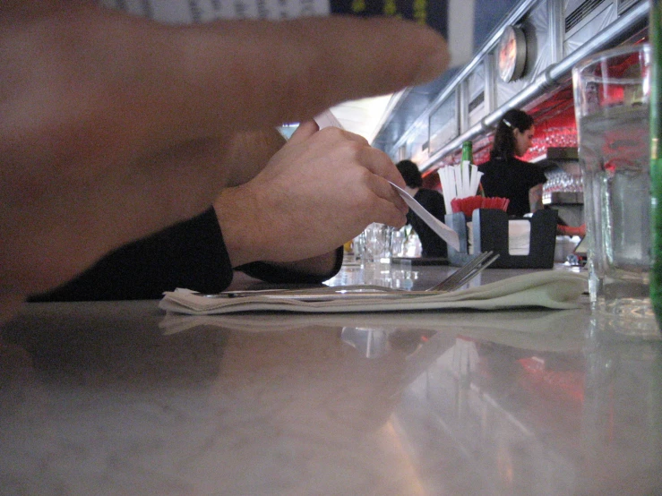 a person putting a drink onto a plate and a newspaper