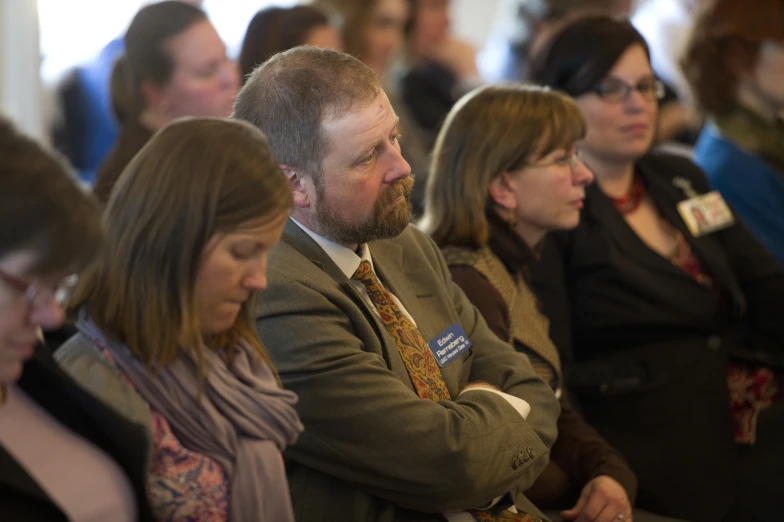 a group of people sitting down with their eyes closed