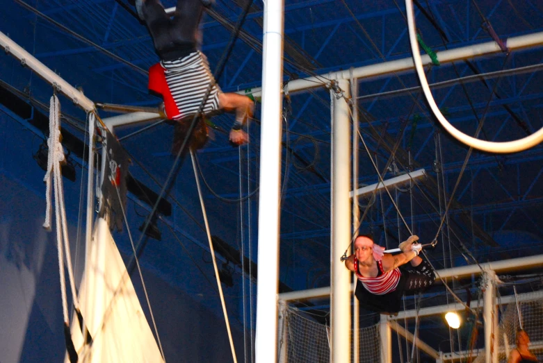 two men are performing acrobatic on an indoor ring