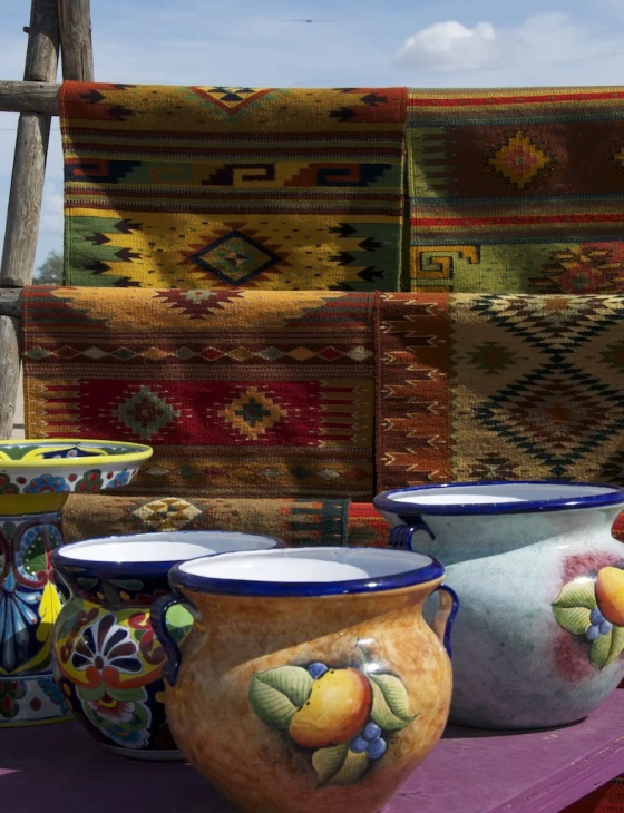 colorful pieces of pottery sit in front of a rug