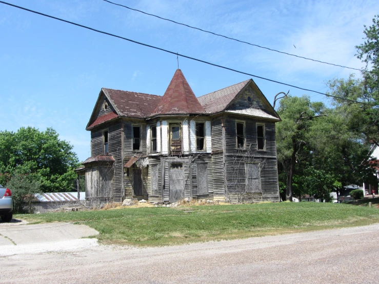 an old abandoned house sits on the corner of a vacant street