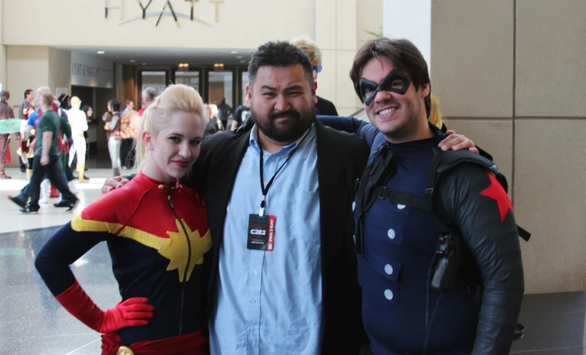 three people pose together for a po in front of a crowd