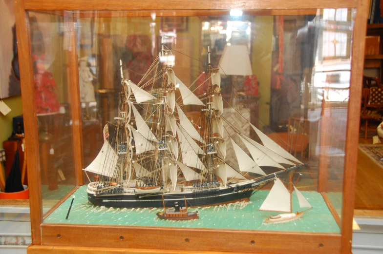 a display case holds a model ship on a table