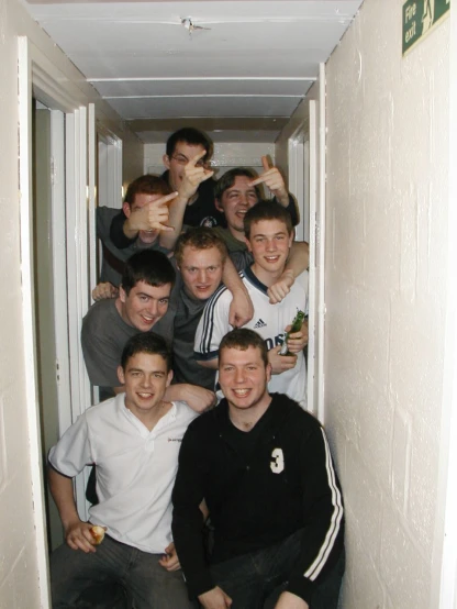 a group of young men standing inside of a hallway