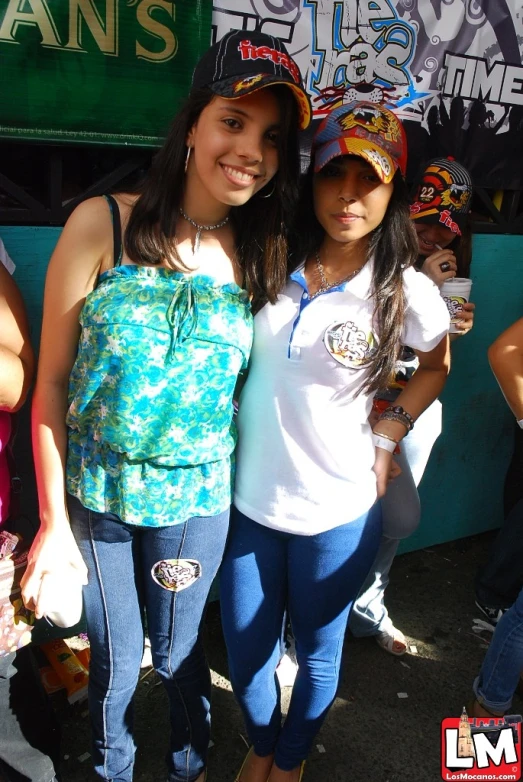 two young ladies who are standing near a sign