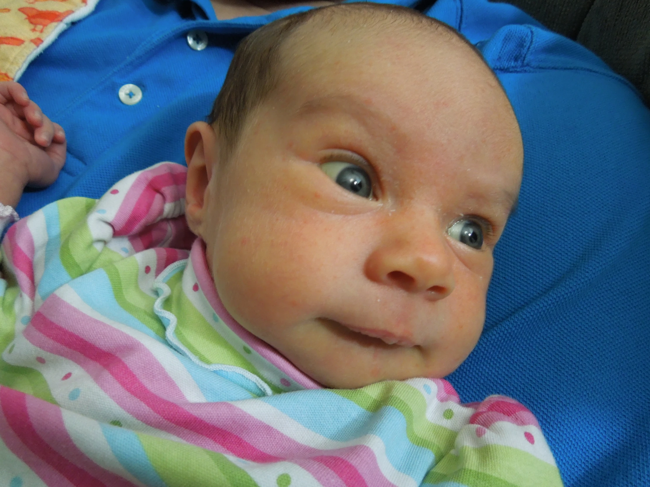 an infant covered in a blanket laying on its back