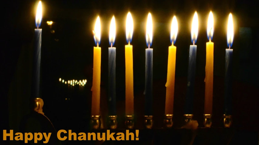 a group of lit candles in a black room