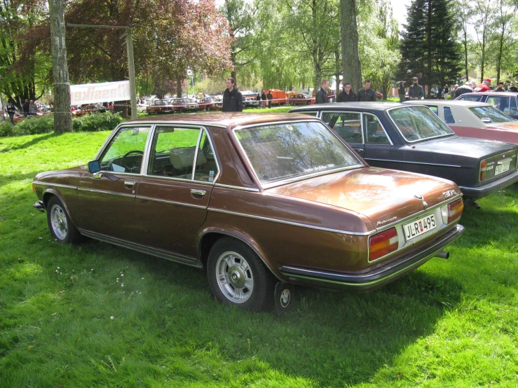 a number of cars parked on a grass field